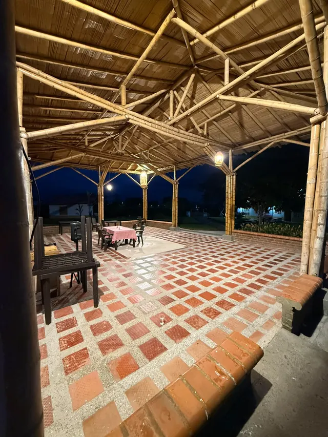 Interior del salón comedor con estructura de madera y piso en ladrillo