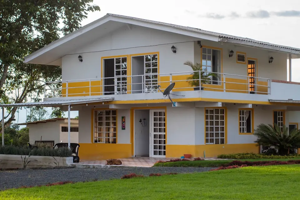 Casa principal de Sol de Maíz con balcón y detalles amarillos