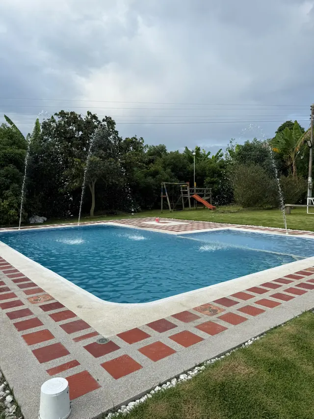 Piscina con chorros de agua y piso en ladrillo
