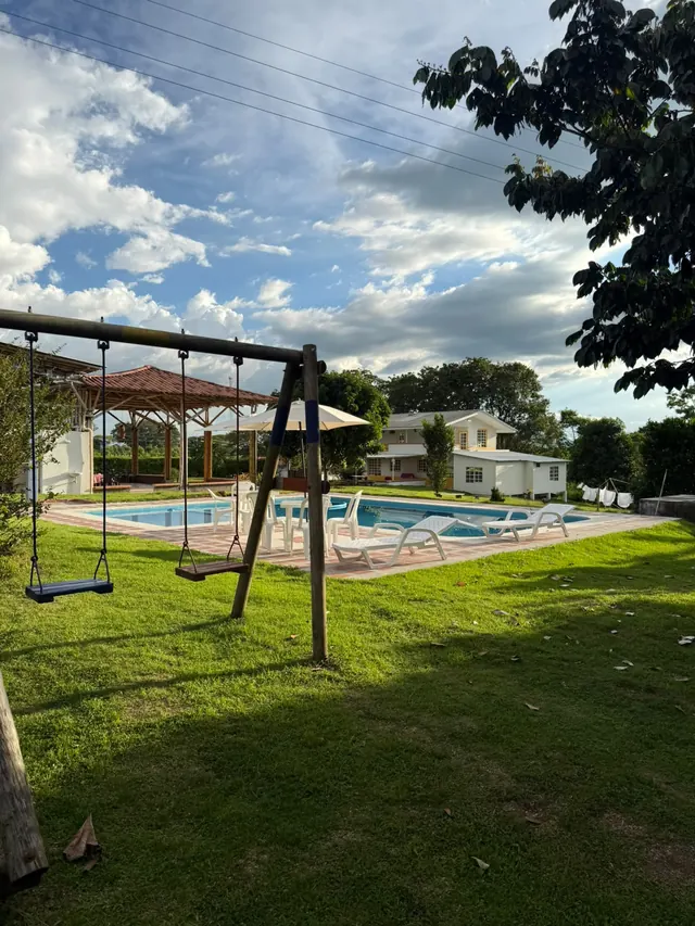 Piscina con columpios y zona verde para niños
